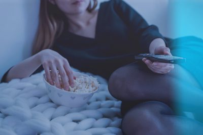 Imagen de una mujer en la cama viendo una película