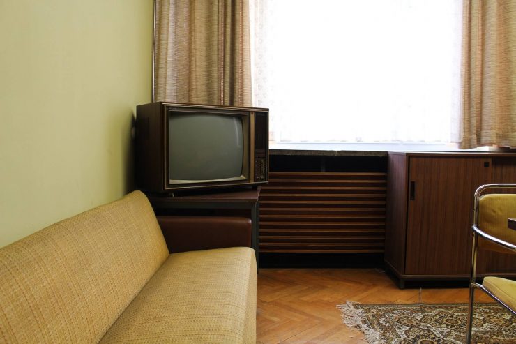 Un televisor antiguo colocado en una acogedora sala de estar, evocando nostalgia y recuerdos de épocas pasadas